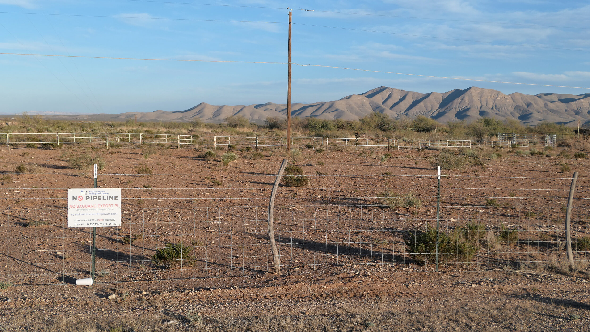 The proposed route of the Saguaro pipeline passes close to this property south of Van Horn. A sign in opposition to the pipeline is attached to the fence. Credit: Martha Pskowski/Inside Climate News